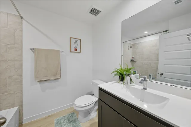 a bathroom with a granite countertop sink a toilet and a mirror