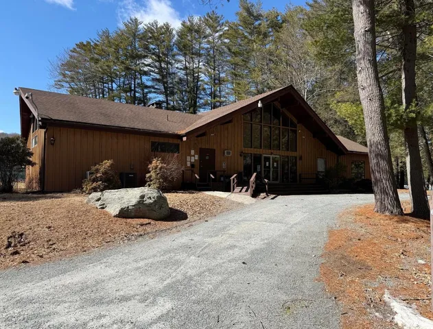 a view of a house with backyard and trees