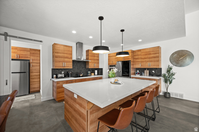 507 West Windmill Gate Cove Draper, UT 84020 - Photo 16 of 46 Kitchen with a barn door, wood finish cabinetry, modern cabinets, freestanding refrigerator, and a kitchen island