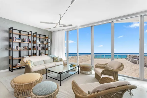 a living room with furniture and a floor to ceiling window