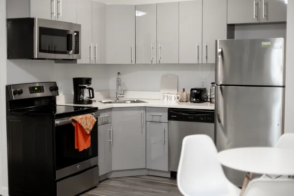 a kitchen with stainless steel appliances granite countertop a refrigerator stove a sink and a microwave