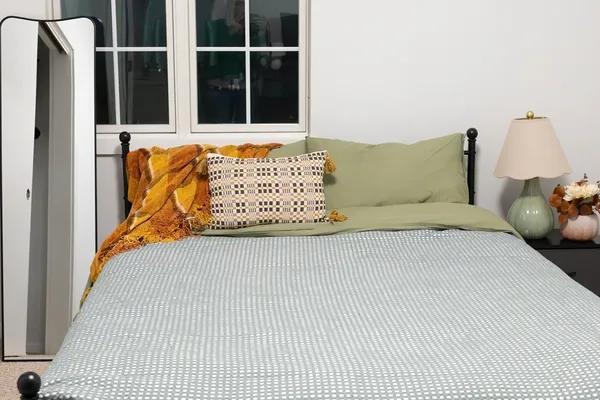 a bed sitting in a bedroom next to a window