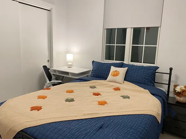 a large bed sitting in a bedroom next to a window