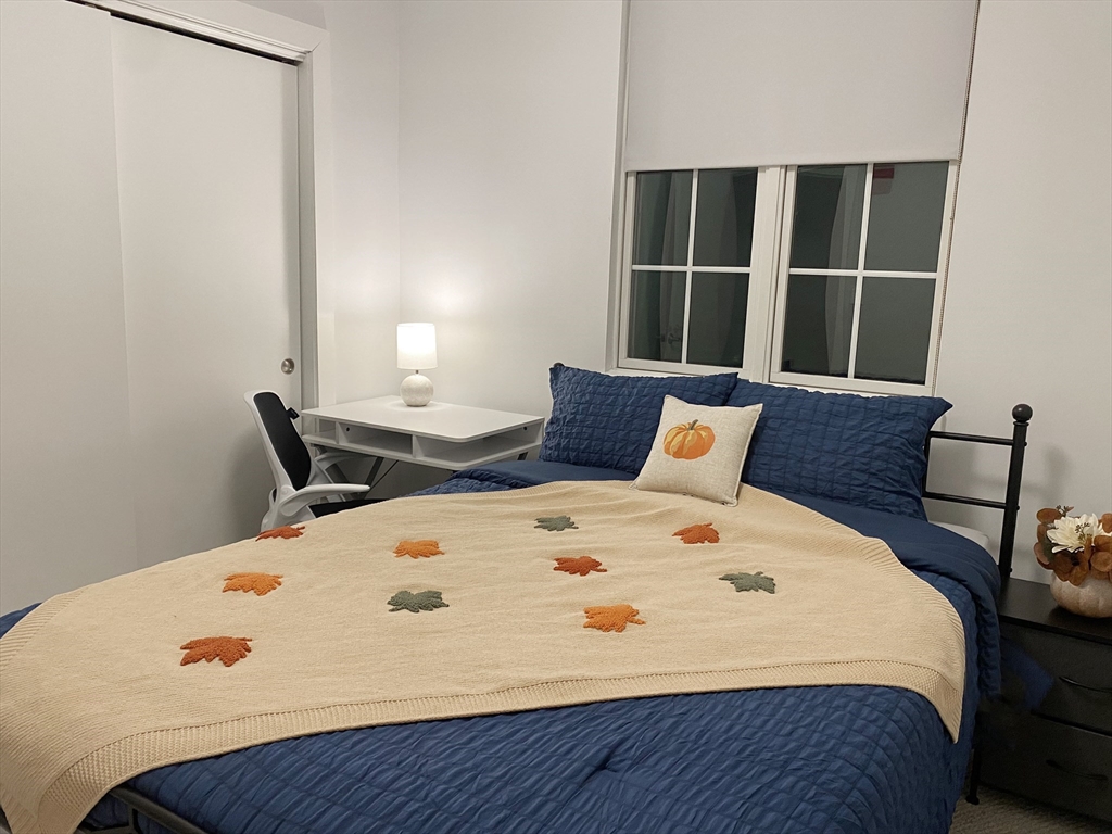 1505 Commonwealth Avenue, Unit 501 Boston, MA 02135 - Photo 10 of 10 a large bed sitting in a bedroom next to a window