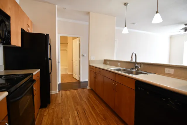 a kitchen with a sink a counter top space stainless steel appliances and cabinets