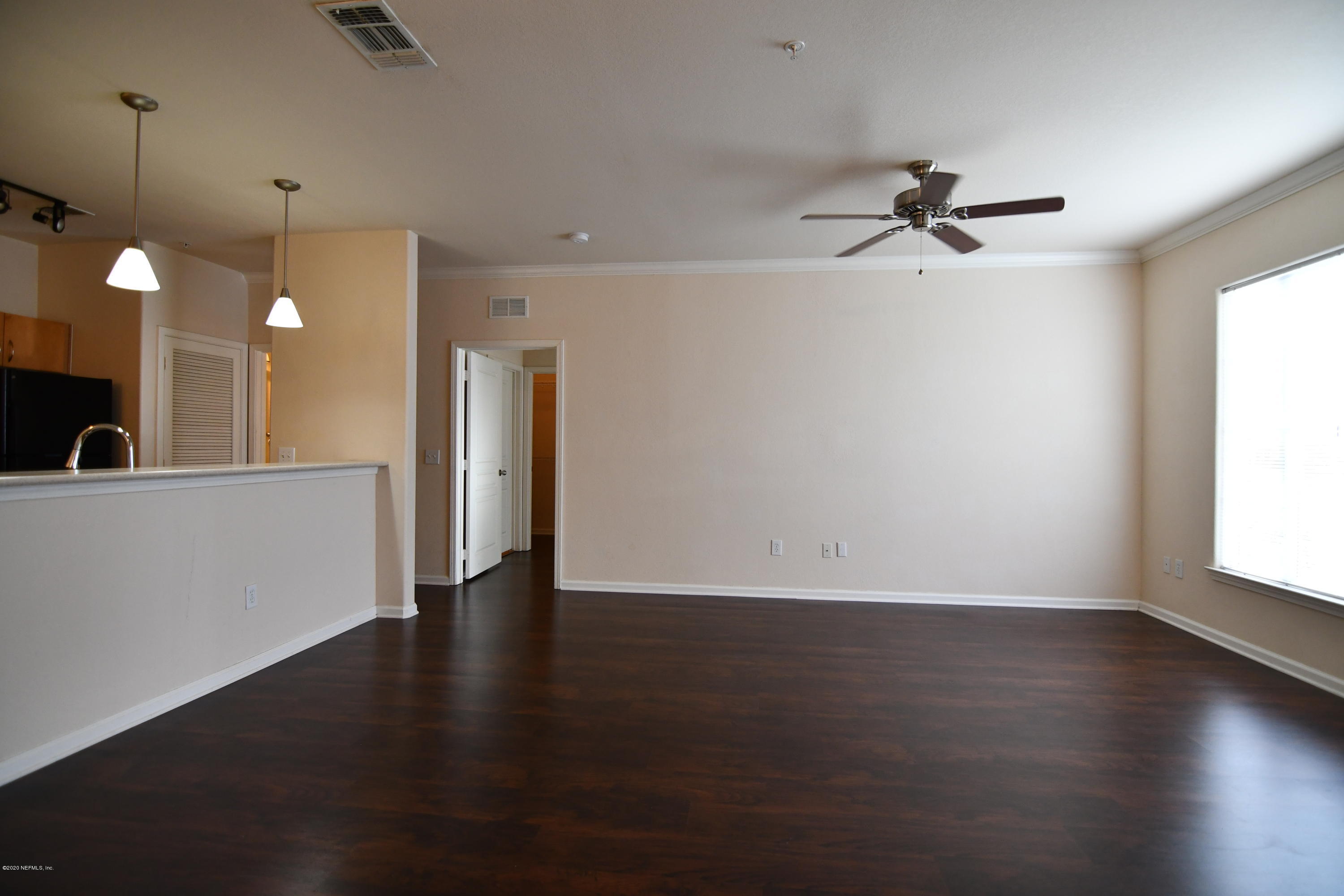 8290 Gate Parkway West, Unit 206 Jacksonville, FL 32216 - Photo 2 of 19 a view of an empty room with a window and wooden floor