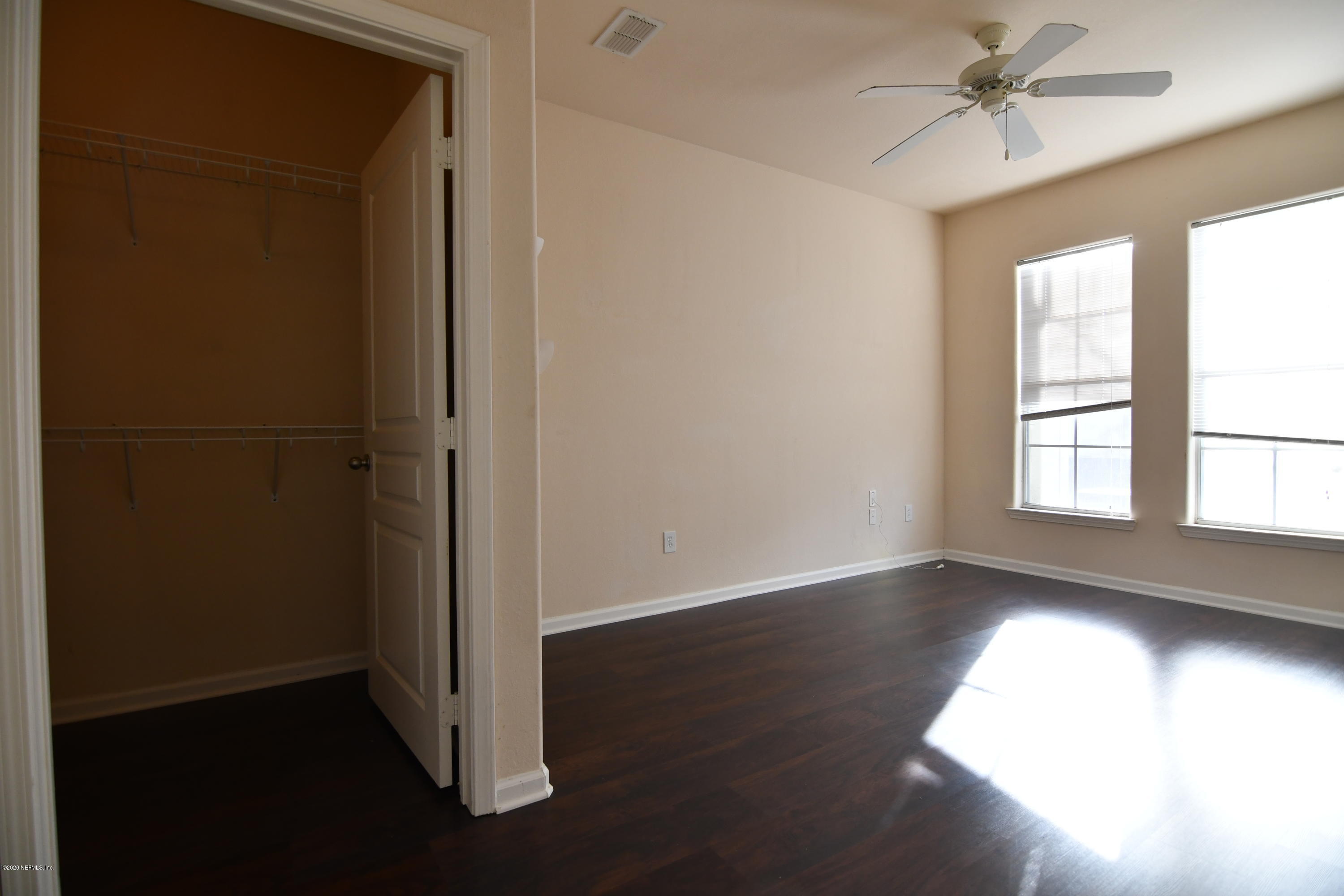 8290 Gate Parkway West, Unit 206 Jacksonville, FL 32216 - Photo 9 of 19 an empty room with wooden floor cabinet and windows