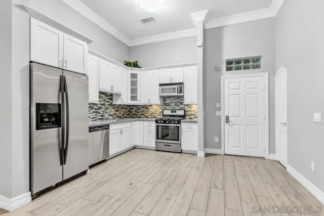 a kitchen with stainless steel appliances a refrigerator and a stove top oven