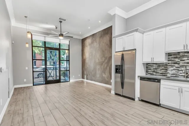 a view of a kitchen with stainless steel appliances wooden floor and a window