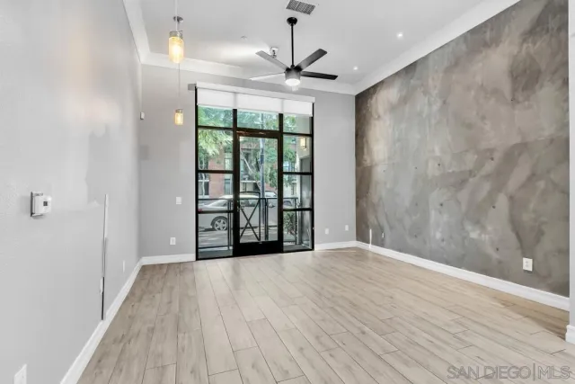 a view of an empty room with a window and wooden floor
