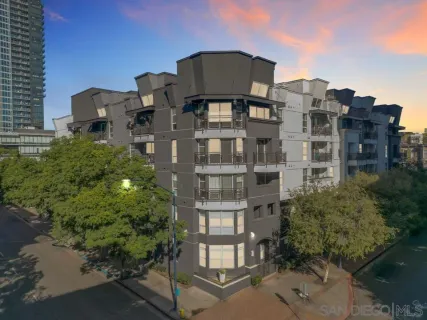 a front view of a residential apartment building with a yard and plants