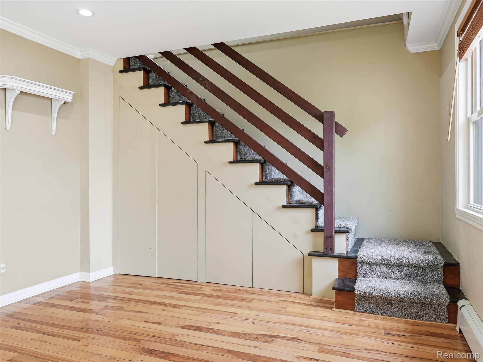 117 Kenyon Road Algonac, MI 48001 - Photo 25 of 47 Staircase featuring wood-finish railings, carpeted treads, and integrated storage doors below