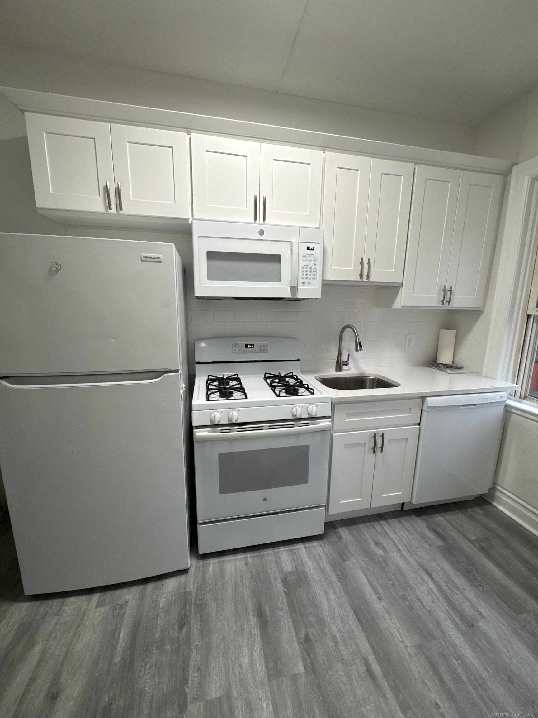 351 Greenwich Avenue, Unit 3 Greenwich, CT 06830 - Photo 2 of 8 a kitchen with granite countertop white cabinets and white appliances