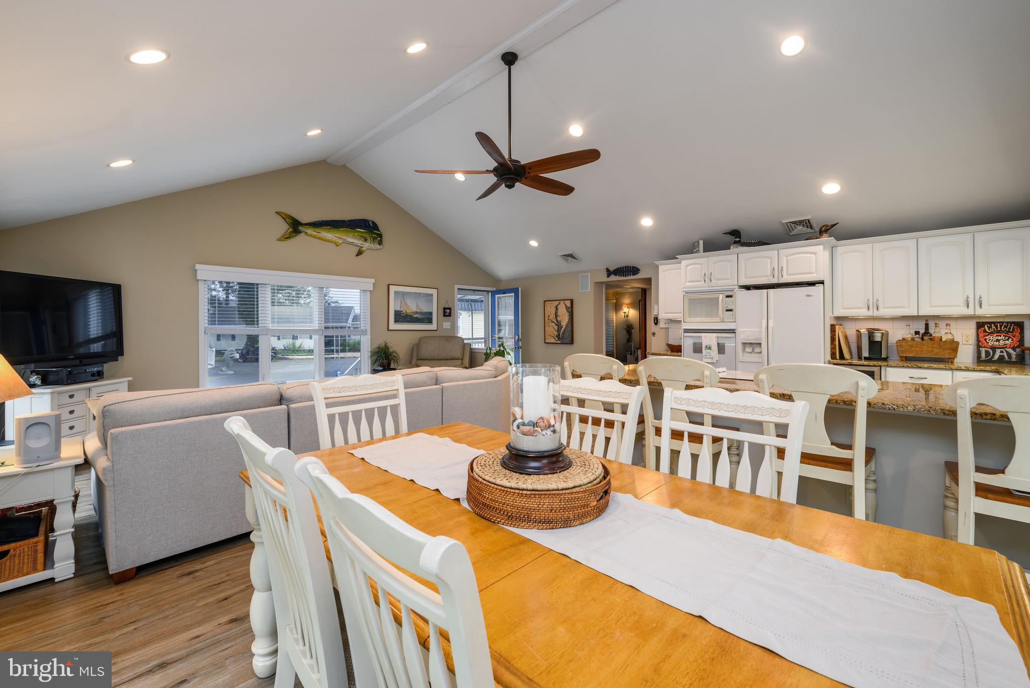 34386 Mallard Road, Unit 482 Long Neck, DE 19966 - Photo 11 of 41 a living room with stainless steel appliances kitchen island granite countertop a table chairs and a view of kitchen