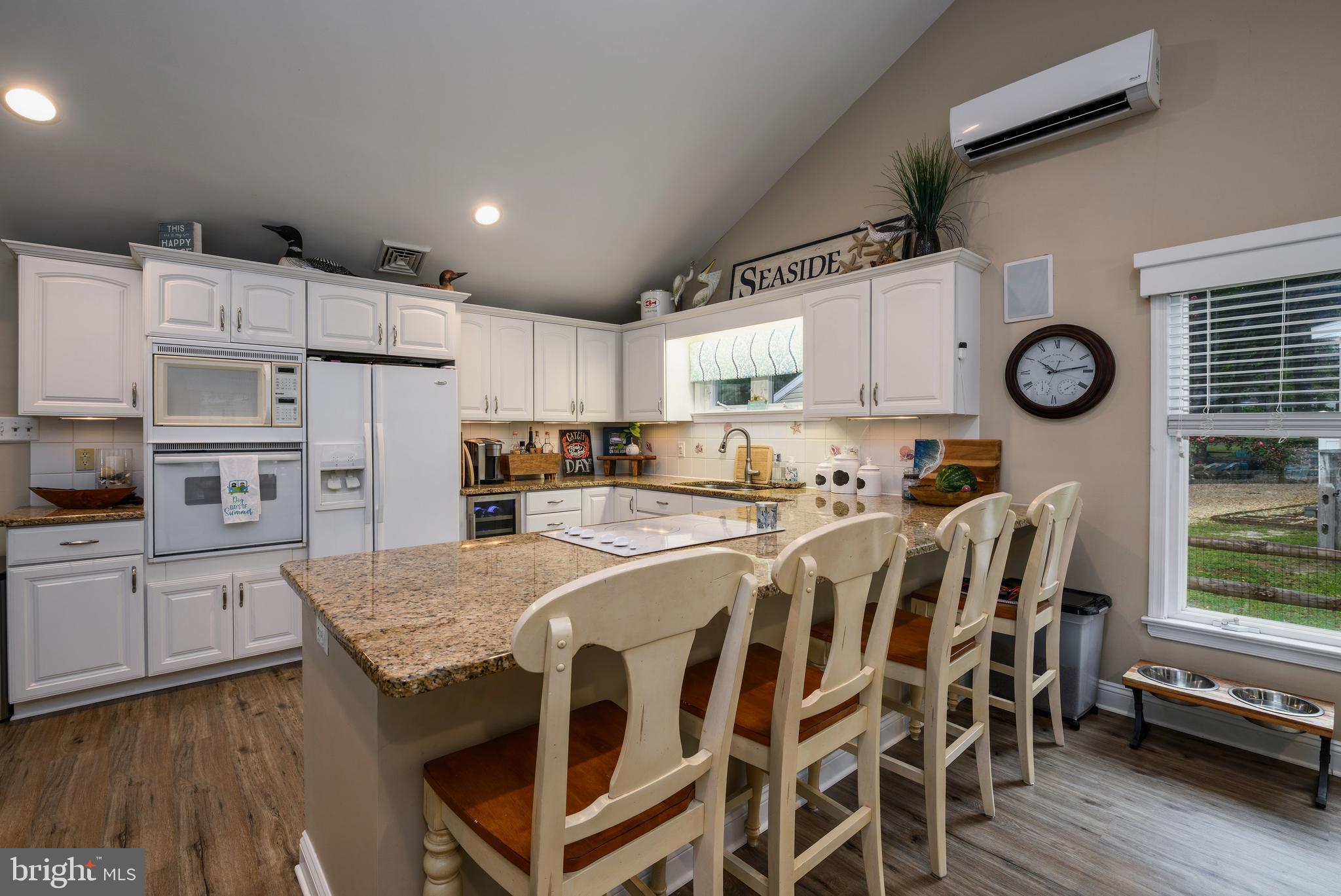 34386 Mallard Road, Unit 482 Long Neck, DE 19966 - Photo 13 of 41 a large kitchen with kitchen island a wooden floor and white appliances