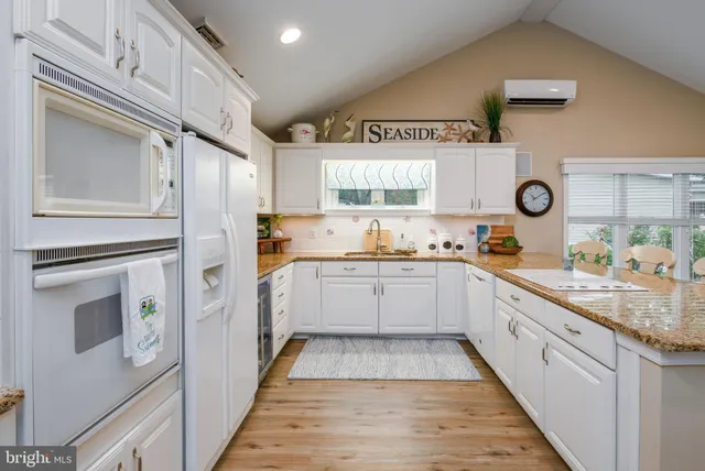 a kitchen with stainless steel appliances granite countertop a sink a stove and cabinets