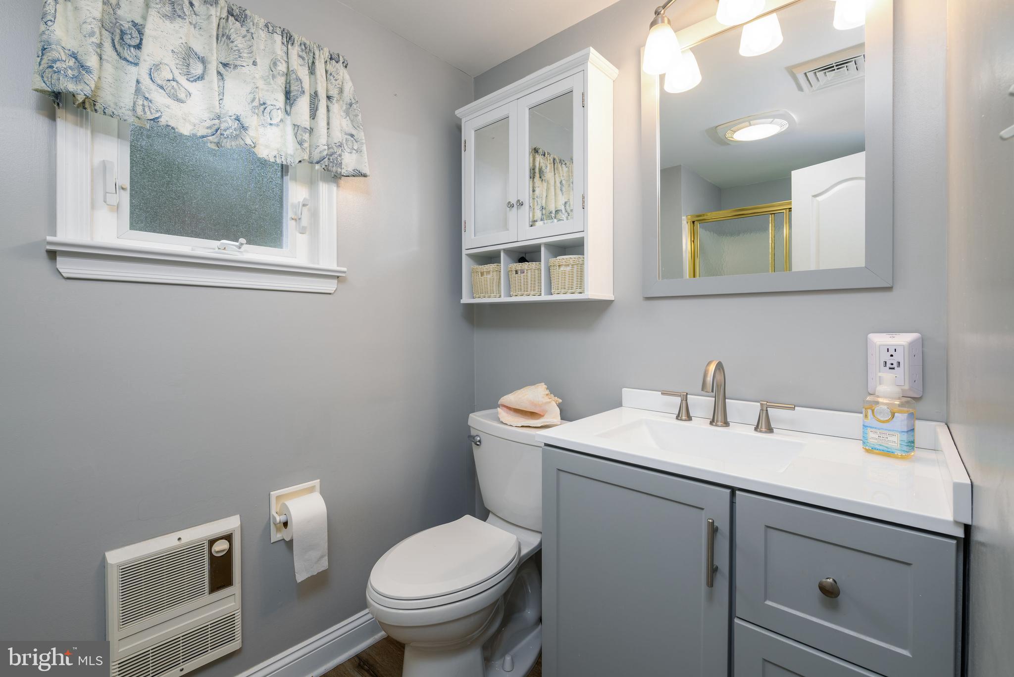 34386 Mallard Road, Unit 482 Long Neck, DE 19966 - Photo 23 of 41 a bathroom with a toilet sink and mirror