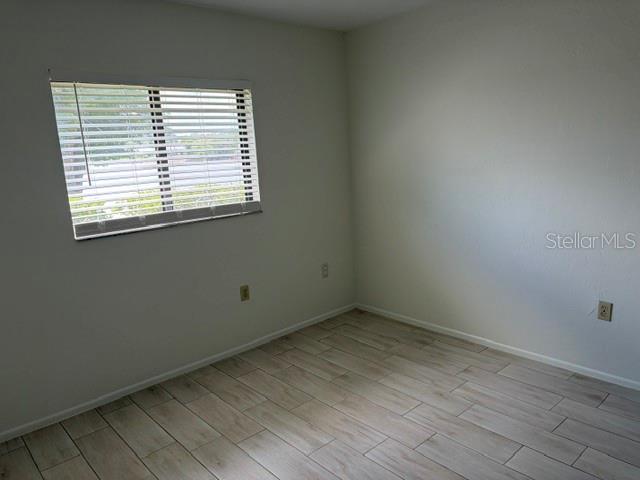 25225 Rampart Boulevard, Unit 1702 Punta Gorda, FL 33983 - Photo 11 of 19 an empty room with wooden floor and windows