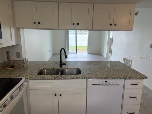 25225 Rampart Boulevard, Unit 1702 Punta Gorda, FL 33983 - Photo 3 of 19 a kitchen with white cabinets and a sink