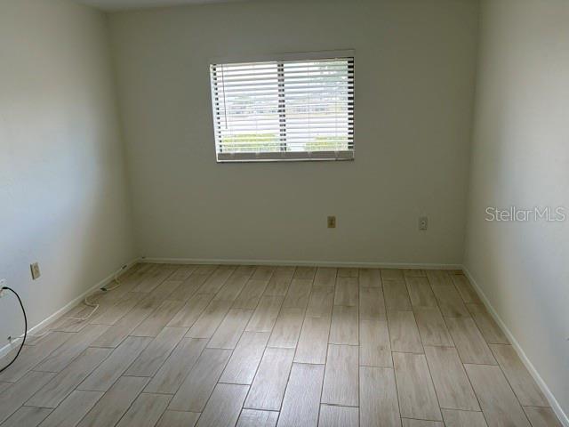 25225 Rampart Boulevard, Unit 1702 Punta Gorda, FL 33983 - Photo 10 of 19 an empty room with wooden floor and windows