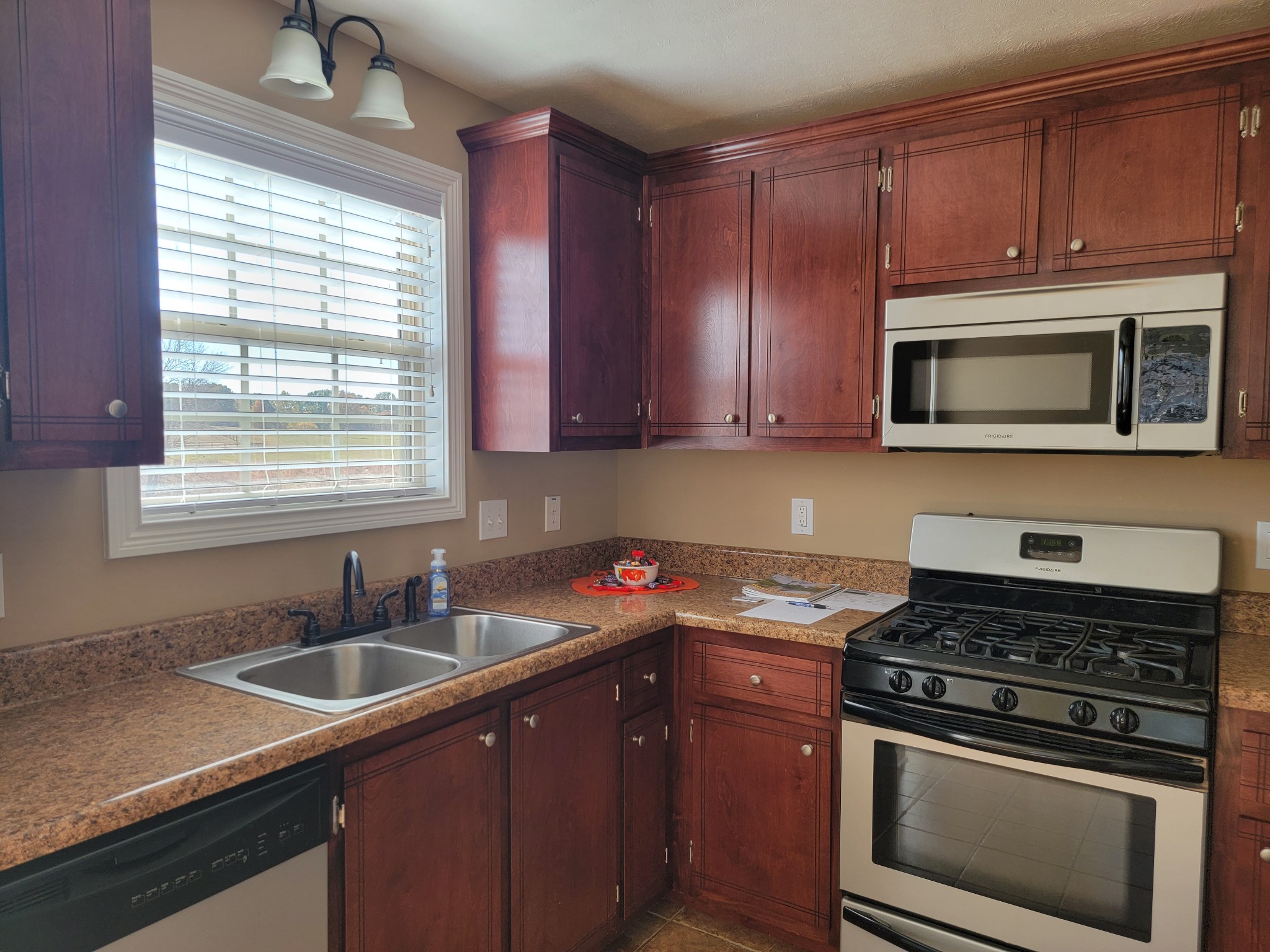 834 7 Mile Ferry Road Clarksville, TN 37040 - Photo 4 of 15 a kitchen with wooden cabinets stove top oven and microwave