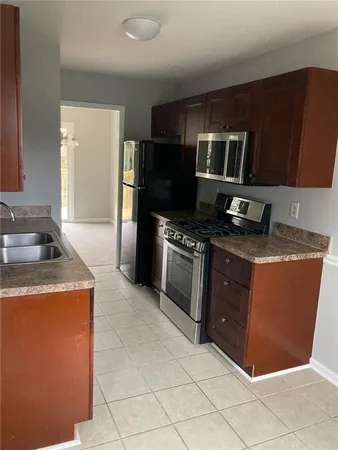 a kitchen with stainless steel appliances granite countertop a stove a refrigerator and a sink