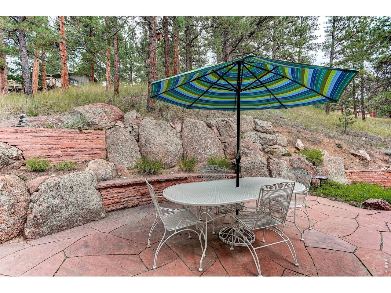65 Betasso Road Boulder, CO 80302 - Photo 29 of 38 a patio with a table and chairs under an umbrella
