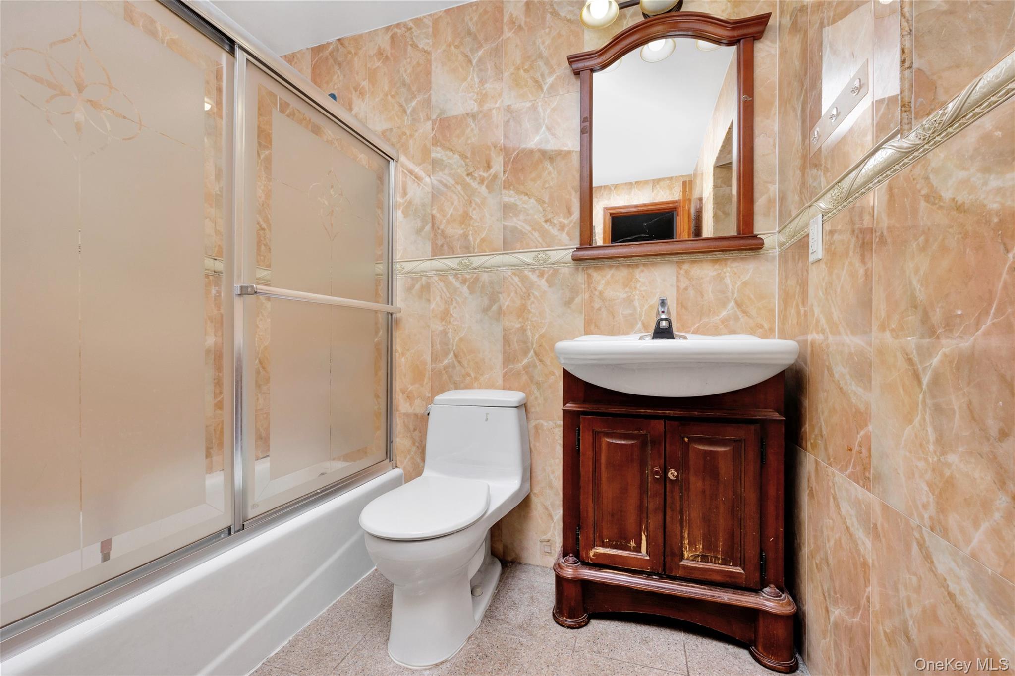 132-36 Pople Avenue, Unit 3A Queens, NY 11355 - Photo 20 of 24 Bathroom featuring tile walls, vanity, and shower / bath combination with glass door