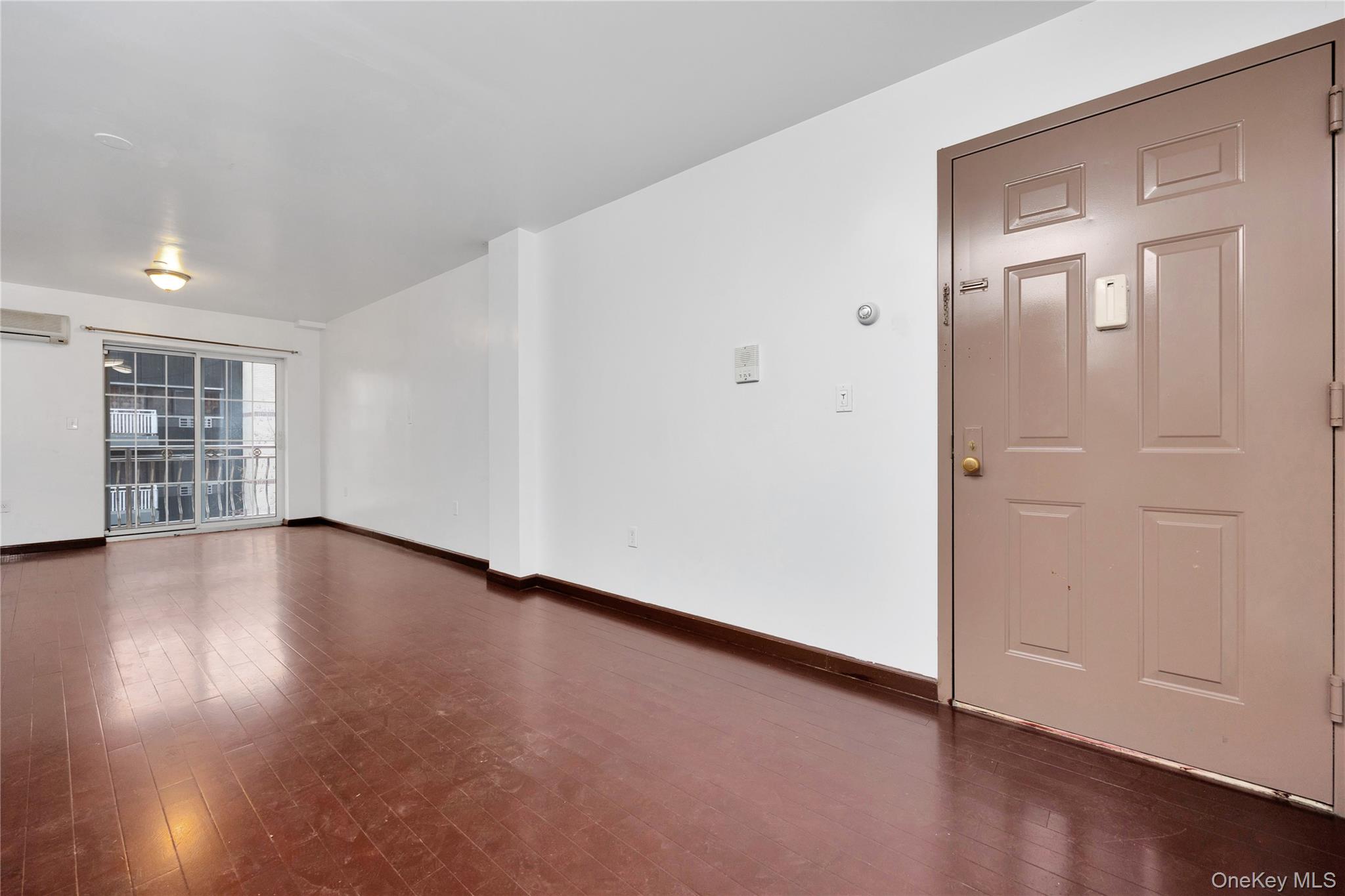 132-36 Pople Avenue, Unit 3A Queens, NY 11355 - Photo 4 of 24 Unfurnished room with dark wood finished floors and an AC wall unit