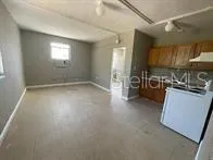 a view of kitchen with stove and cabinets