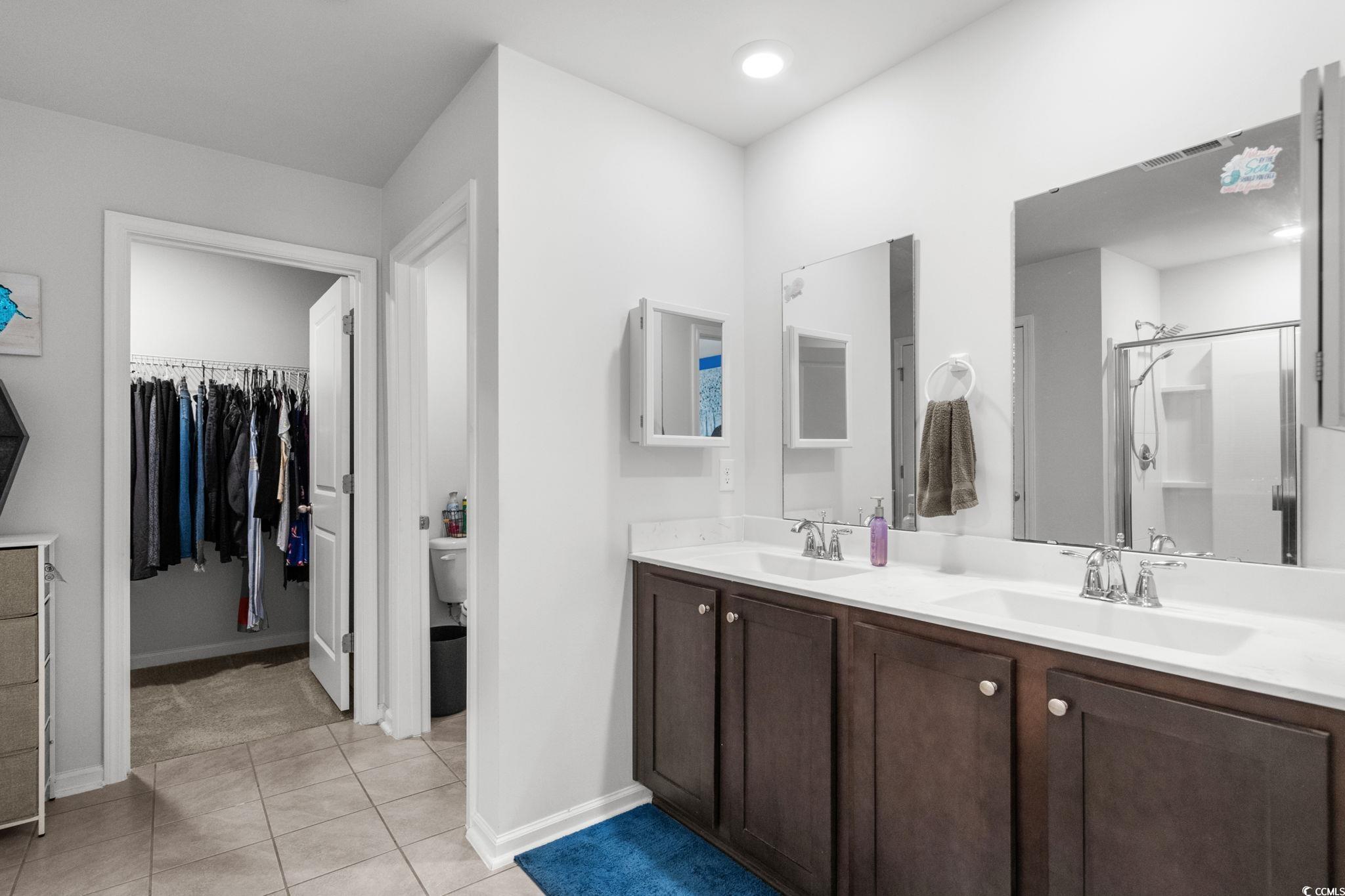 899 Snowberry Drive Longs, SC 29568 - Photo 13 of 27 Bathroom featuring light tile patterned floors, a stall shower, double vanity, and a spacious closet