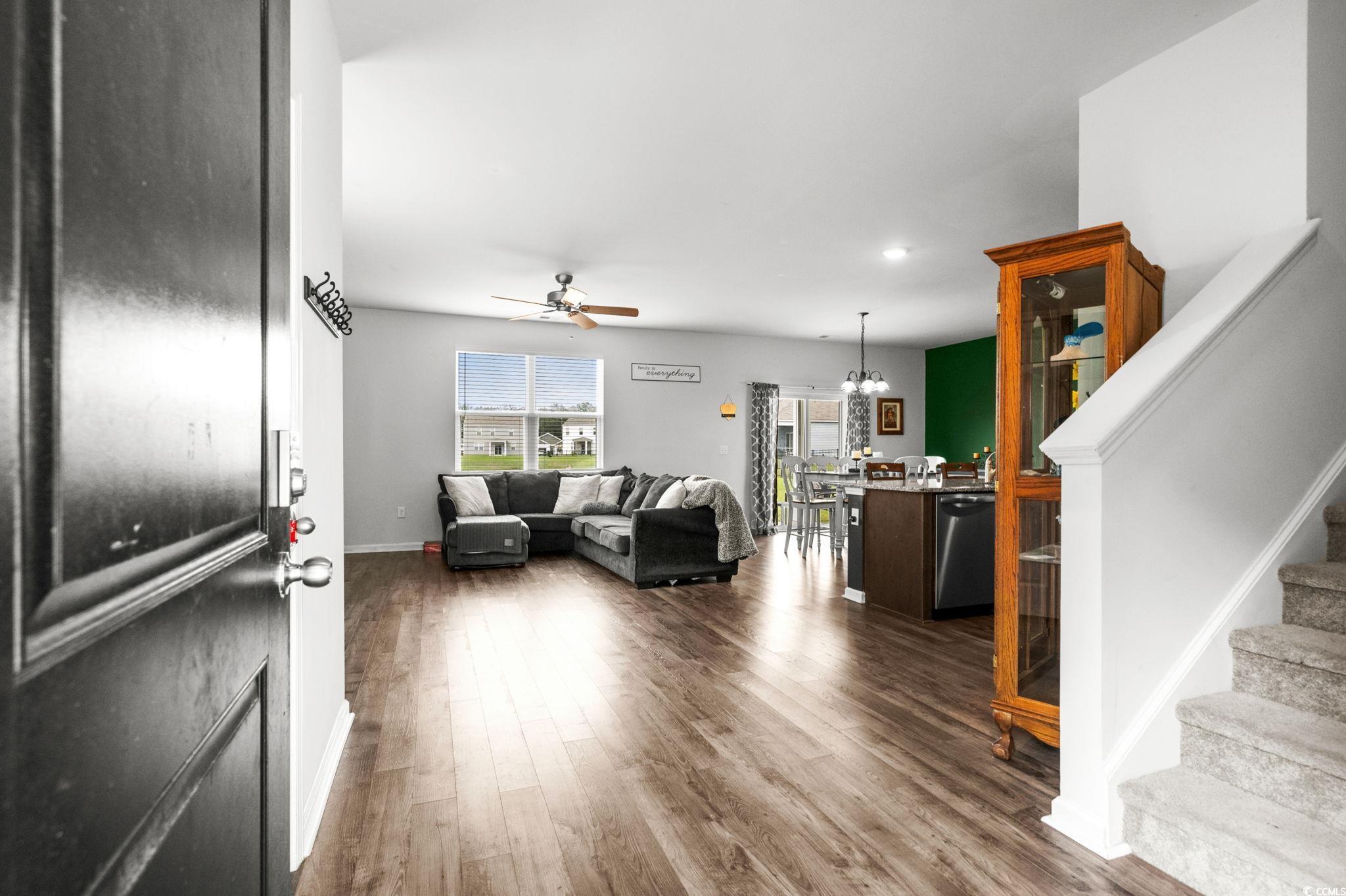 899 Snowberry Drive Longs, SC 29568 - Photo 2 of 27 Living area featuring stairway, a chandelier, dark wood-style floors, and a ceiling fan