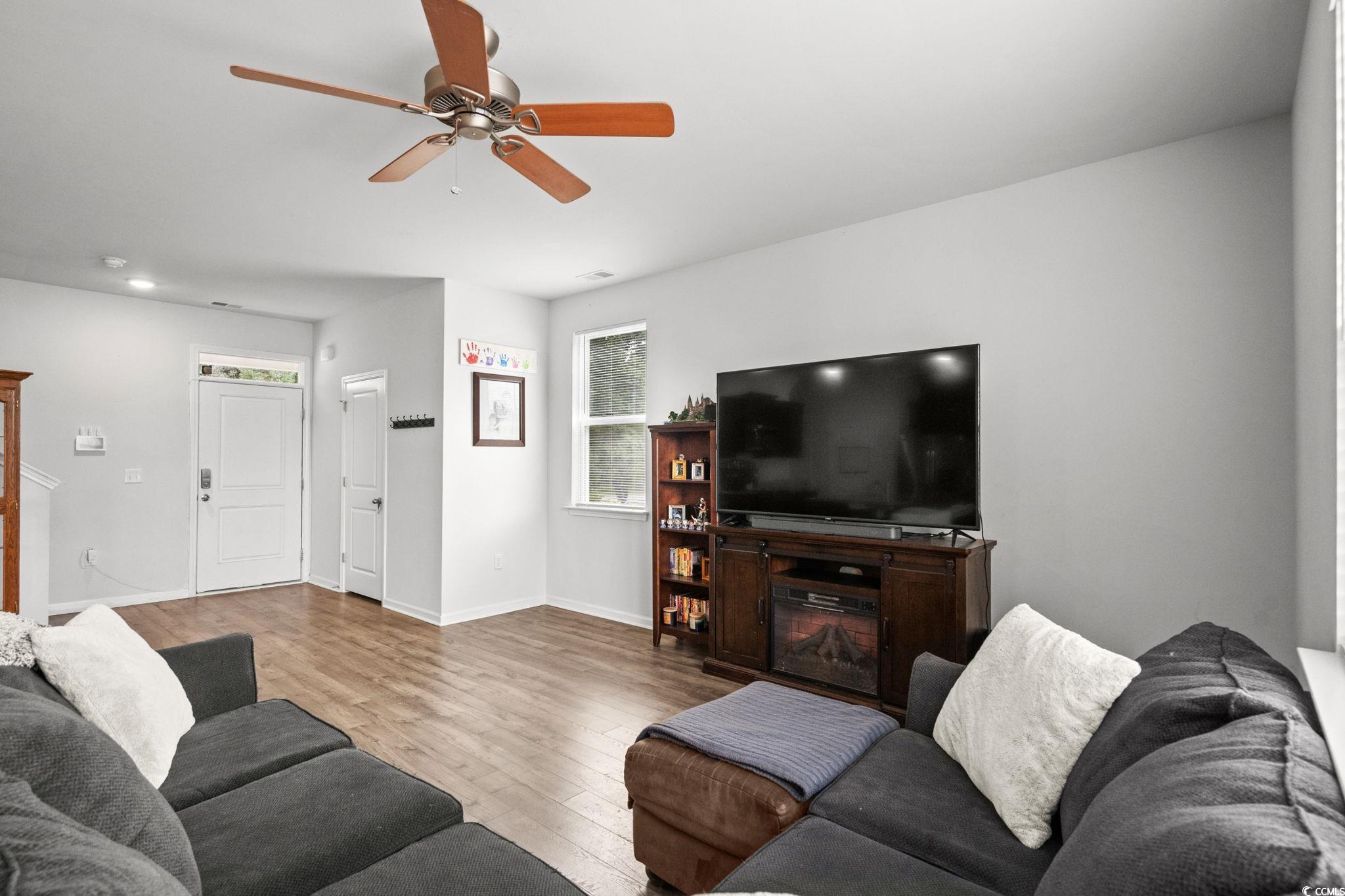 899 Snowberry Drive Longs, SC 29568 - Photo 5 of 27 Living area featuring wood finished floors, ceiling fan, and a glass covered fireplace