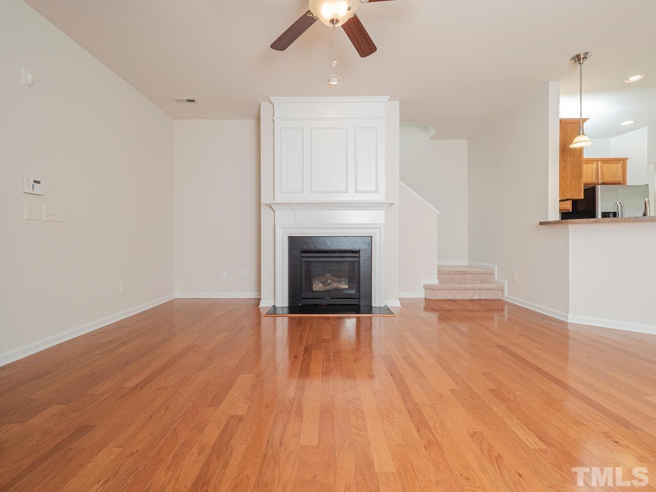 7004 Racine Way Raleigh, NC 27690 - Photo 8 of 27 a view of empty room with wooden floor and fireplace
