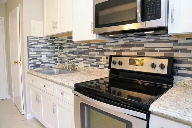 a stove top oven sitting inside of a kitchen