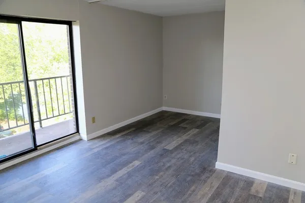 a view of a room with wooden floor and large window