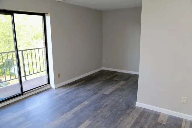 a view of a room with wooden floor and large window