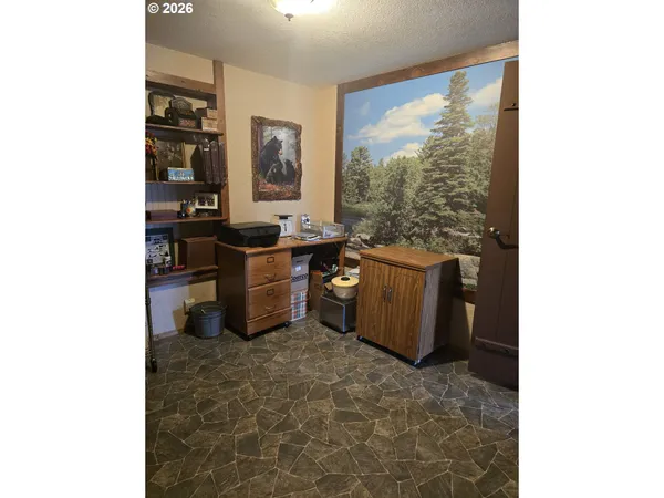 a backyard of a house with barbeque oven and trees