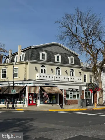 a front view of a building with retail shops and traffic signal