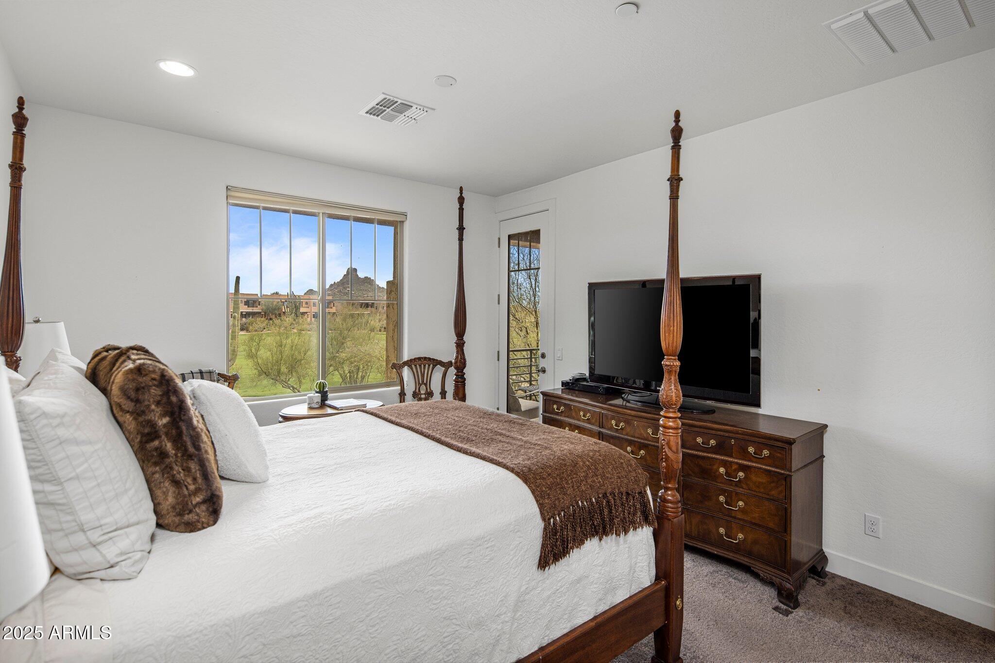 10260 East White Feather Lane, Unit 2003 Scottsdale, AZ 85262 - Photo 11 of 24 a bedroom with a bed and a flat tv screen on the dresser