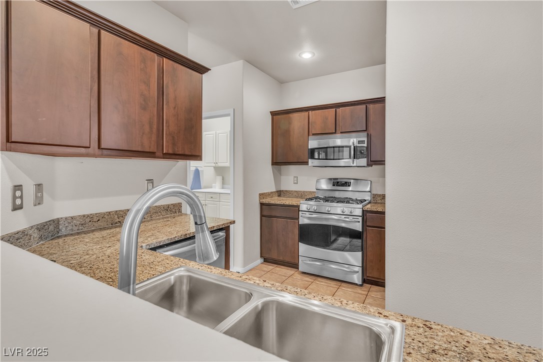 2050 West Warm Springs Road, Unit 1822 Henderson, NV 89014 - Photo 6 of 55 Kitchen featuring a new stainless steel sink and faucet, light granite countertops, and stainless steel appliances