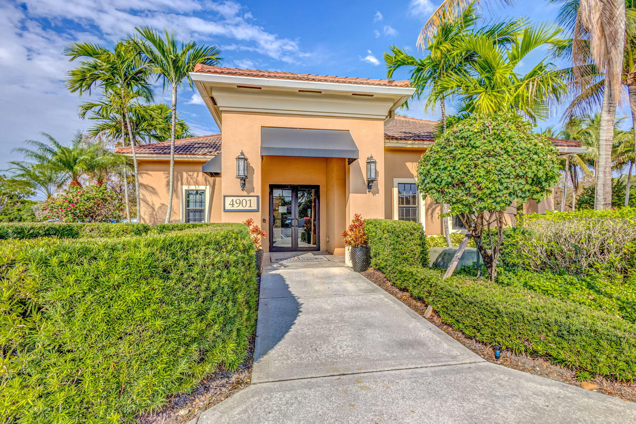 4903 Midtown Lane, Unit 3313 Palm Beach Gardens, FL 33418 - Photo 39 of 81 a view of a house with potted plants and a large tree