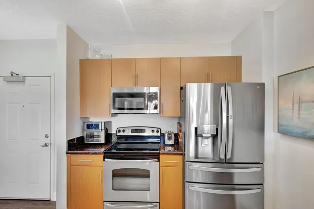 a kitchen with stainless steel appliances a refrigerator stove and microwave
