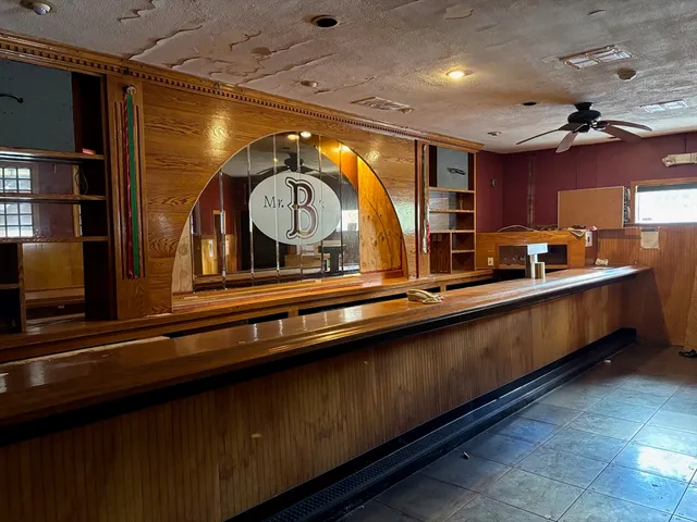 a view of a living room with stainless steel appliances wooden floors