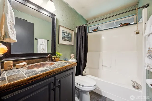 a bathroom with a granite countertop sink toilet and shower
