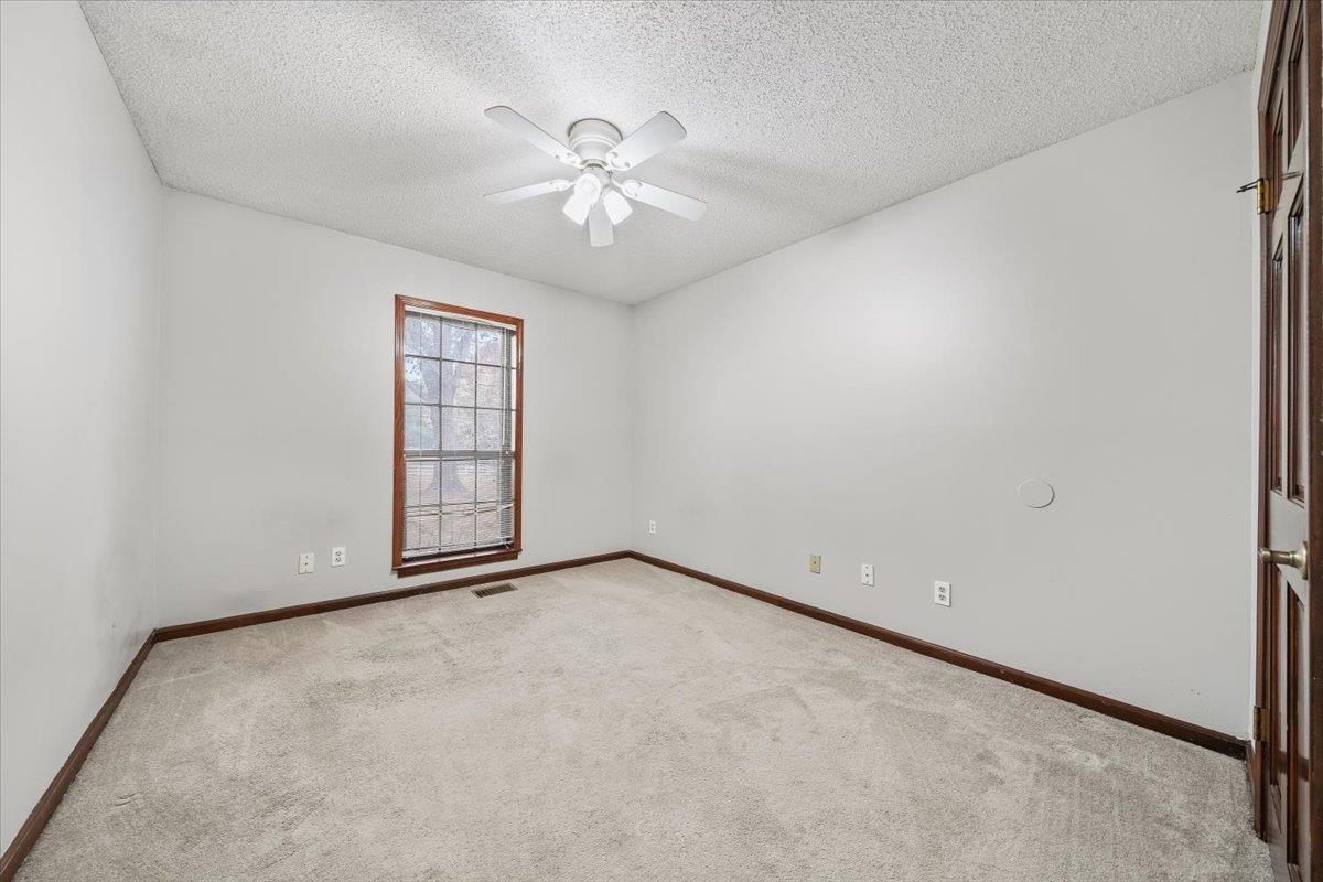 10060 Rosemark Road Atoka, TN 38004 - Photo 17 of 26 an empty room with windows and chandelier fan