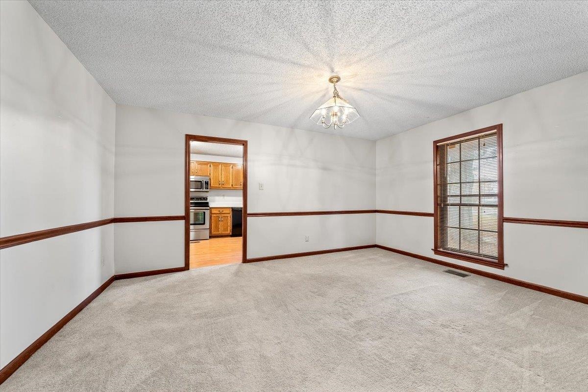 10060 Rosemark Road Atoka, TN 38004 - Photo 7 of 26 an empty room with chandelier fan and windows