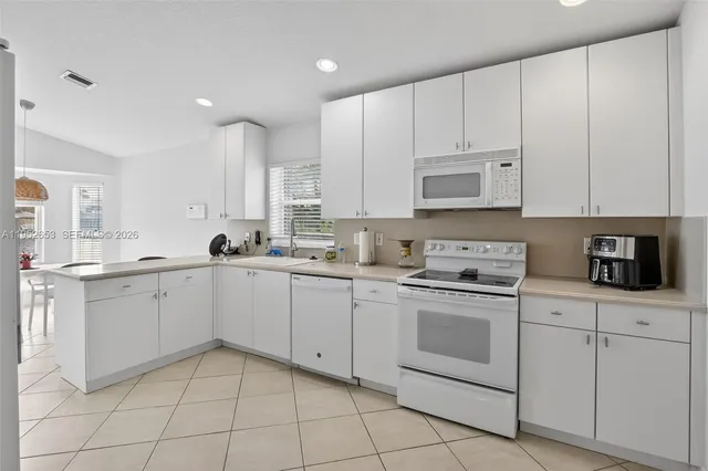 a kitchen with white cabinets appliances and a sink