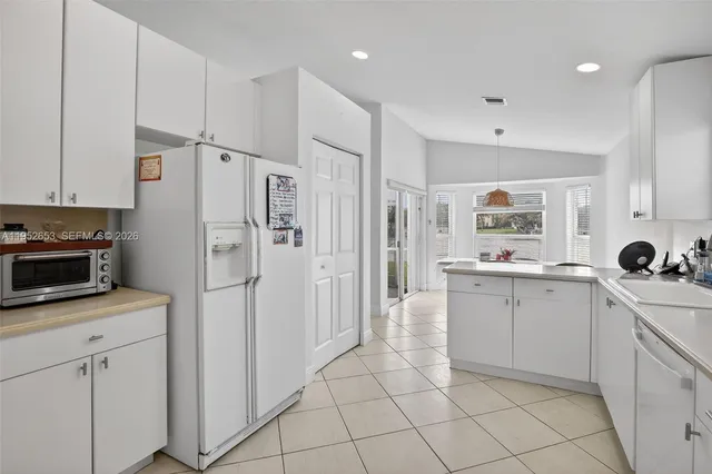a kitchen with white cabinets and white appliances