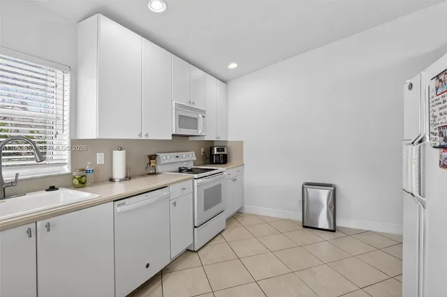 a kitchen with cabinets appliances a sink and a window